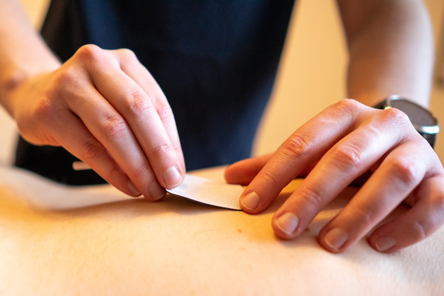 Nakładanie plastra kinesiotaping na plecy